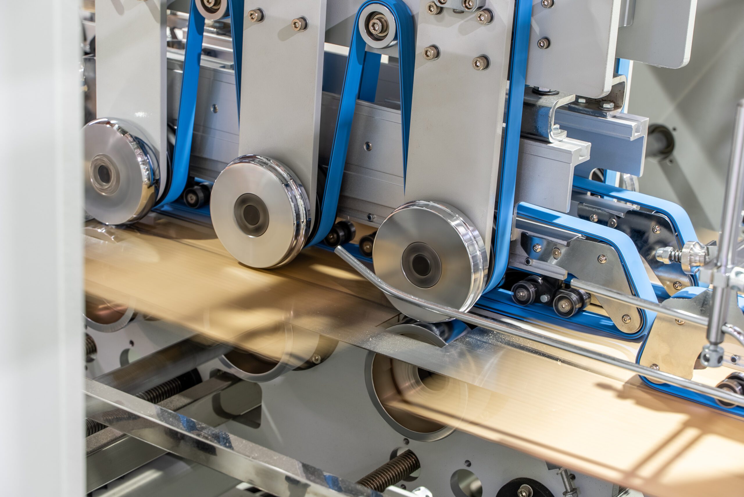 Carton being fed with roller wheels through machinery