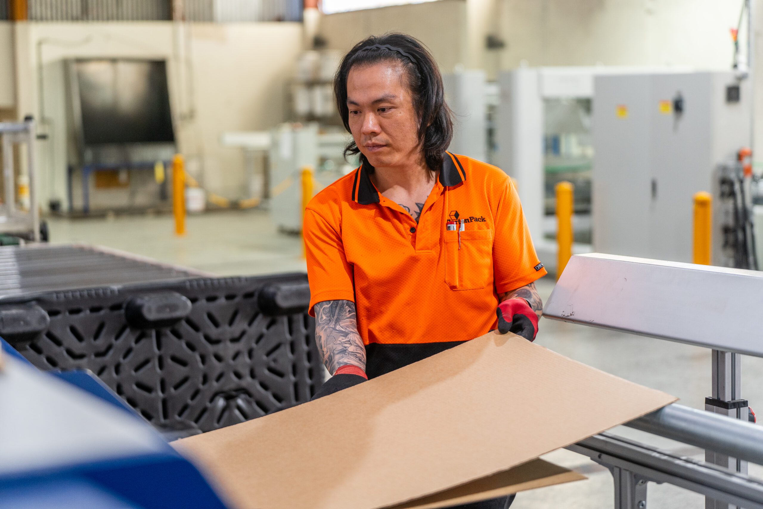 Staff feeding board into machinery